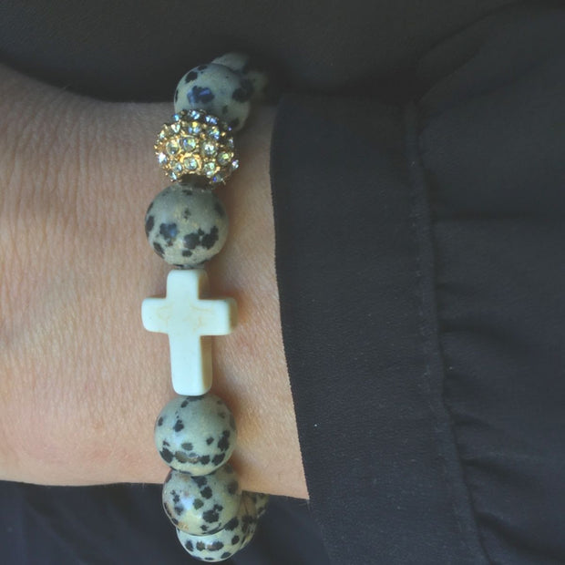 Close-up the ‘Thou Art With Me’ Dalmatian Stone with Ivory Cross Bead Bracelet worn on wrist