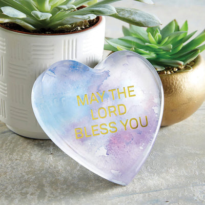 Photo of the May God Bless you paperweight on a table with decor around it.