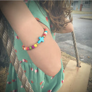 close-up photo of the Colorful ' jesus loves me' Youth bead bracelet with turquoise crosson young girls wrist