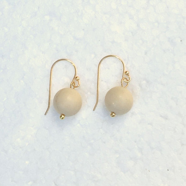 close-up of the  Natural Stone Blessing Earrings—White Fossil bead and Sterling Silver Hook plated in 18k gold