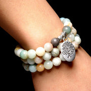 very close-up of the Tree of Life Wrap Amazonite Bead Bracelet on Model's wrist with dark background